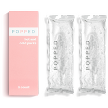Load image into Gallery viewer, 2 Popped reusable hot and cols packs are next to the pink packaging and on a white background