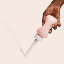 Load image into Gallery viewer, Woman holds peri bottle upside down and squeezes bottle to spray water gently
