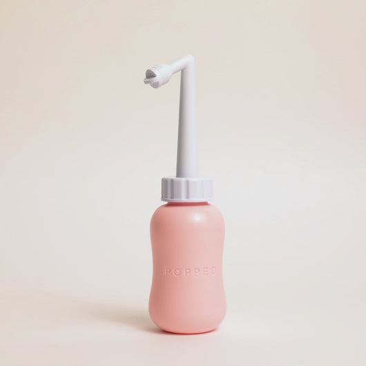 Video of a woman's hands holding the peri bottle and demonstrating how the nozzle is adjustable in length.